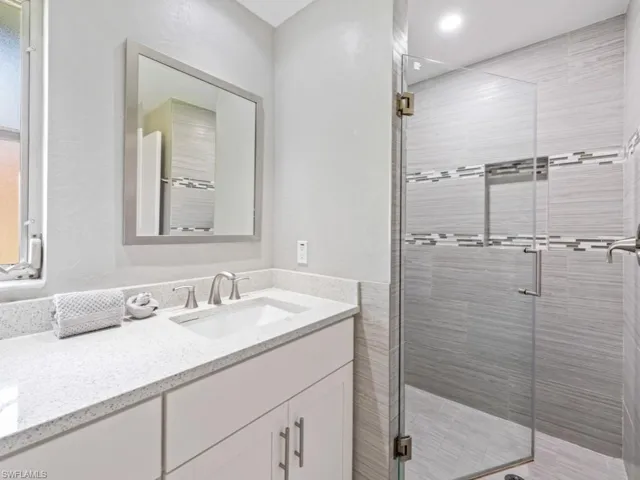 Full bathroom with vanity and a stall shower