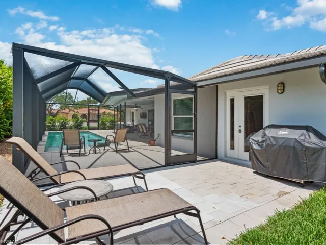 View of patio featuring a lanai, a sunroom, area for grilling, ceiling fan, and an outdoor pool