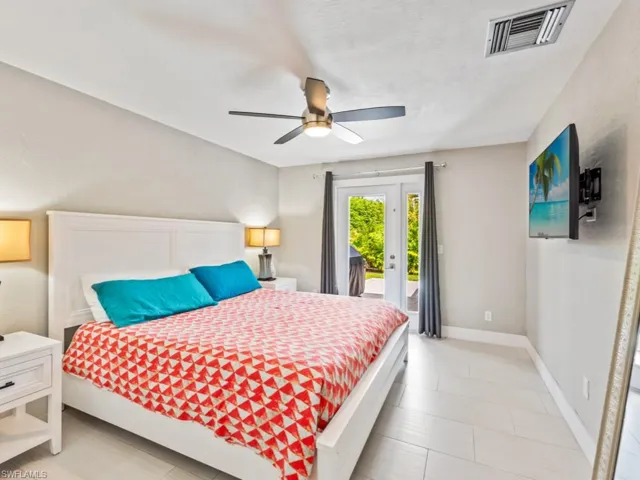 Bedroom with access to exterior, a ceiling fan, and french doors