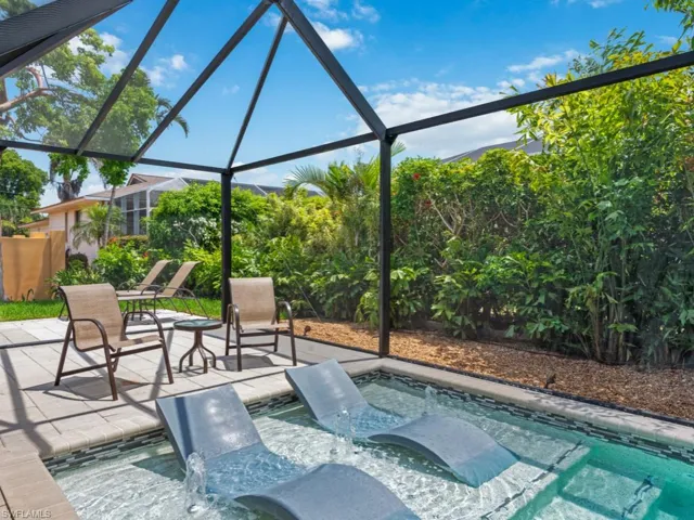 View of swimming pool featuring a sunroom, glass enclosure, a hot tub, and a pool