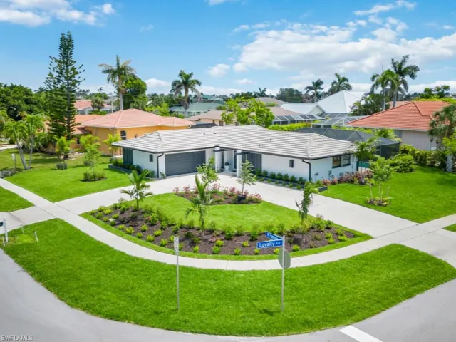 View of front of property featuring curved driveway, a front lawn, a residential view, and a tile roof