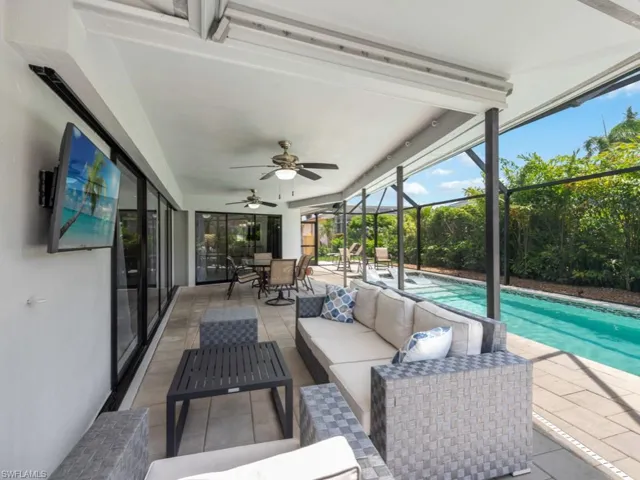 View of patio / terrace featuring an outdoor living space, a sunroom, an outdoor pool, ceiling fan, and outdoor dining space