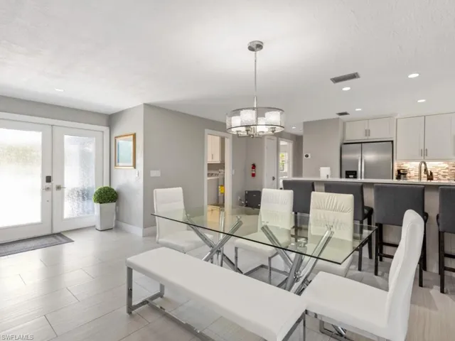 Dining space with french doors, a chandelier, recessed lighting, and a textured ceiling