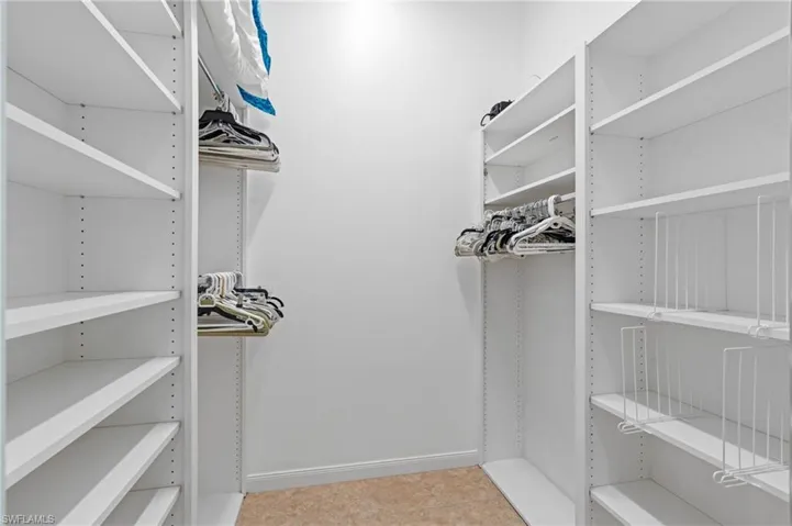 Walk in closet with built-in shelves and storage.