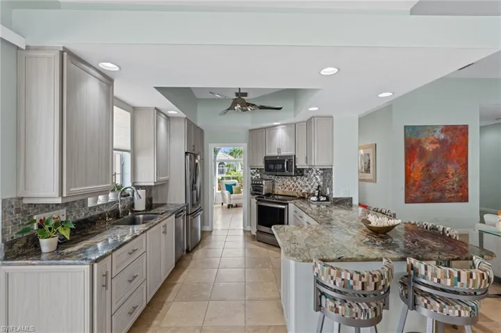 Kitchen featuring a ceiling fan, updated cabinets and breakfast bar.