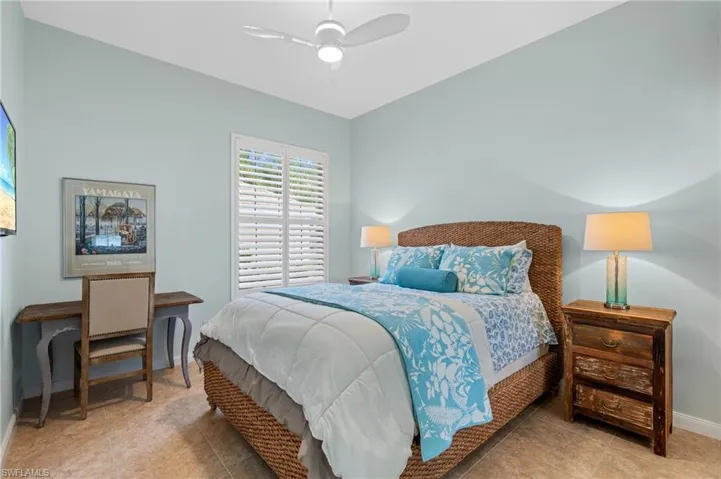 Bedroom with large, mirrored closets and plantation shutters.
