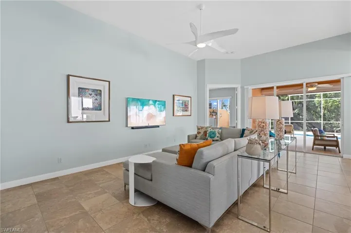 Living area with ceiling fan, designer decor, and high ceilings.