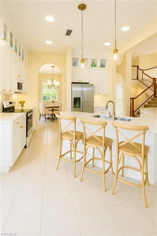 enhanced picture to show kitchen with white taller cabinets and new lighting