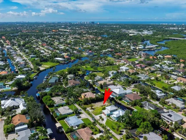 Aerial view of property and surrounding area with a large body of water and nearby suburban area