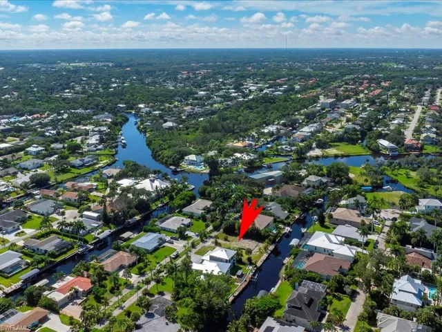 Aerial view of property and surrounding area with a large body of water and nearby suburban area