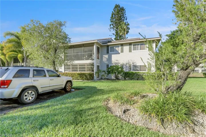 View of front of property featuring a sunroom and a front lawn