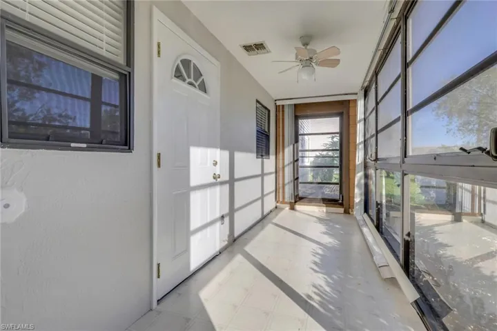 Unfurnished sunroom featuring ceiling fan