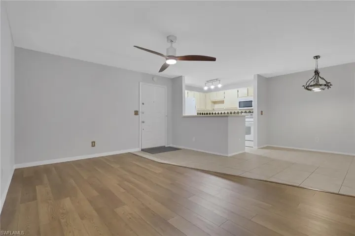 Unfurnished living room featuring light wood-style floors and a ceiling fan