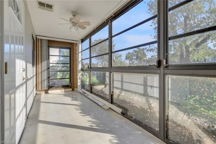Unfurnished sunroom with a ceiling fan, tile patterned floors, and floor to ceiling windows