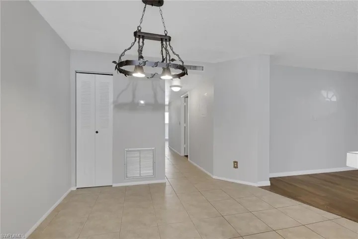 Unfurnished dining area featuring light tile patterned floors, a chandelier, and a textured ceiling
