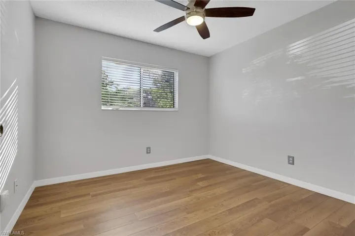 Unfurnished room featuring light wood-style floors, a ceiling fan, and a textured ceiling
