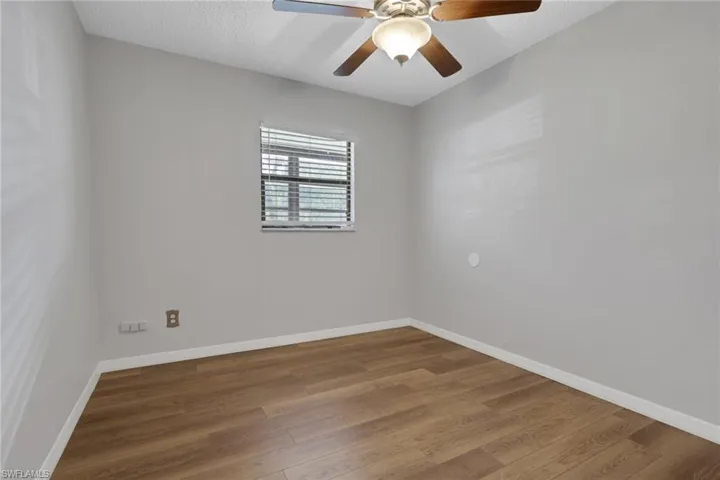 Empty room featuring wood finished floors, a textured ceiling, and ceiling fan