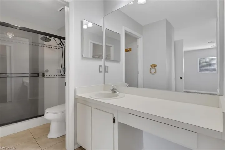 Bathroom with vanity, a shower stall, and light tile patterned flooring