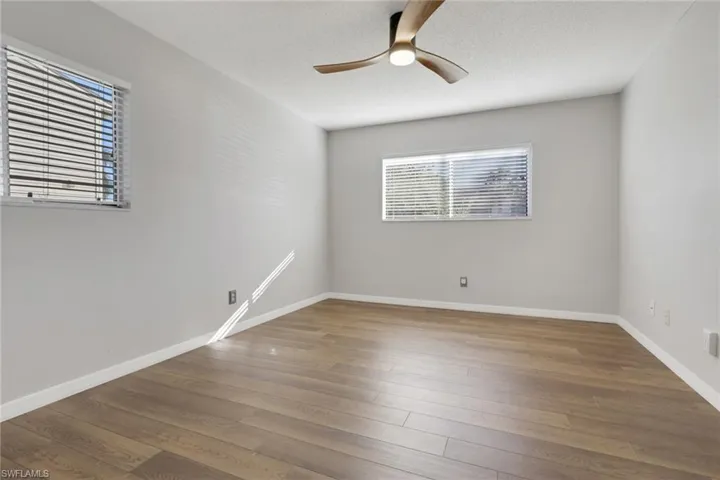 Spare room with light wood finished floors, ceiling fan, and a textured ceiling