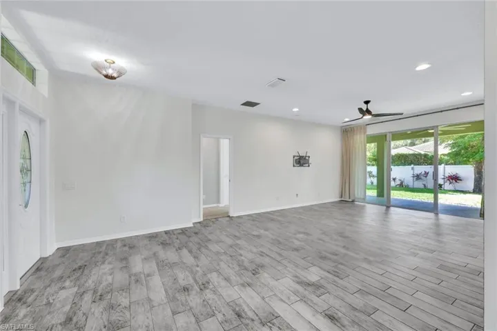 Empty room with ceiling fan and light hardwood / wood-style flooring
