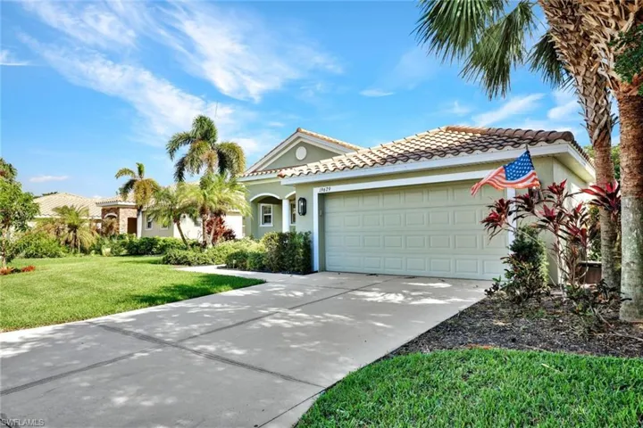 Mediterranean / spanish-style house with a garage and a front lawn