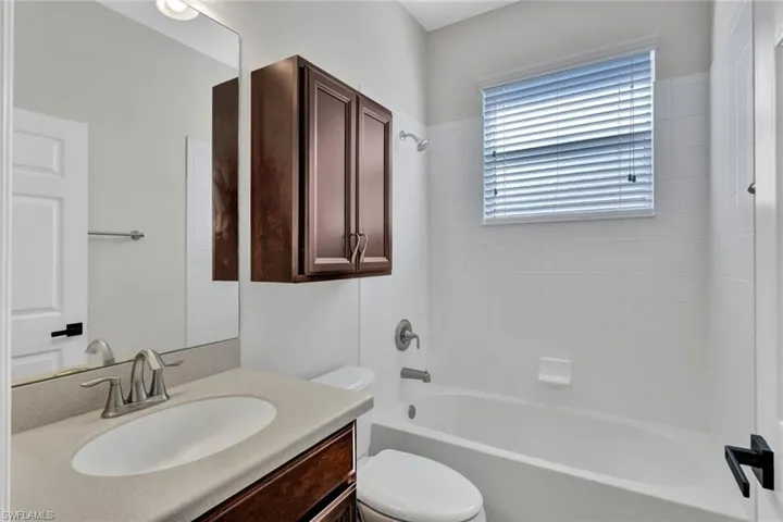 Full bathroom featuring vanity, toilet, and tiled shower / bath