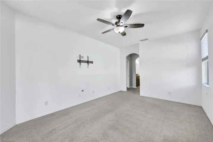 Carpeted empty room with ceiling fan