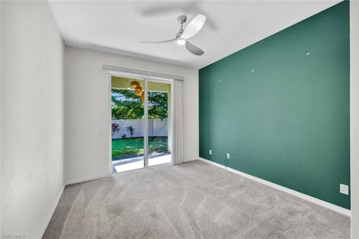 Carpeted empty room with ceiling fan