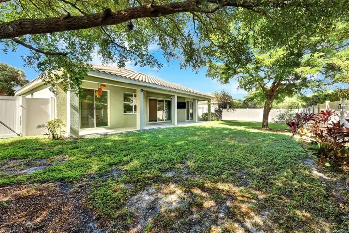Rear view of property featuring a lawn and a patio