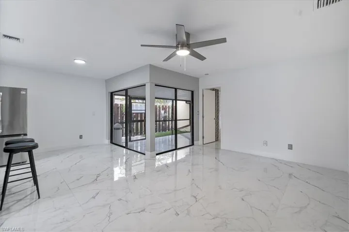 Empty room with light marble finish floors and ceiling fan