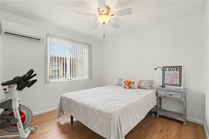 Bedroom featuring light wood-style flooring, ceiling fan, and a textured ceiling