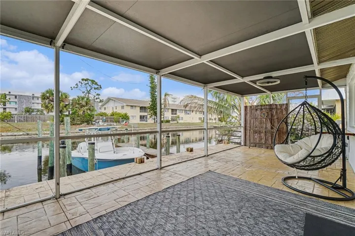 Unfurnished sunroom featuring a patio, a water view, a residential view, and plenty of natural light