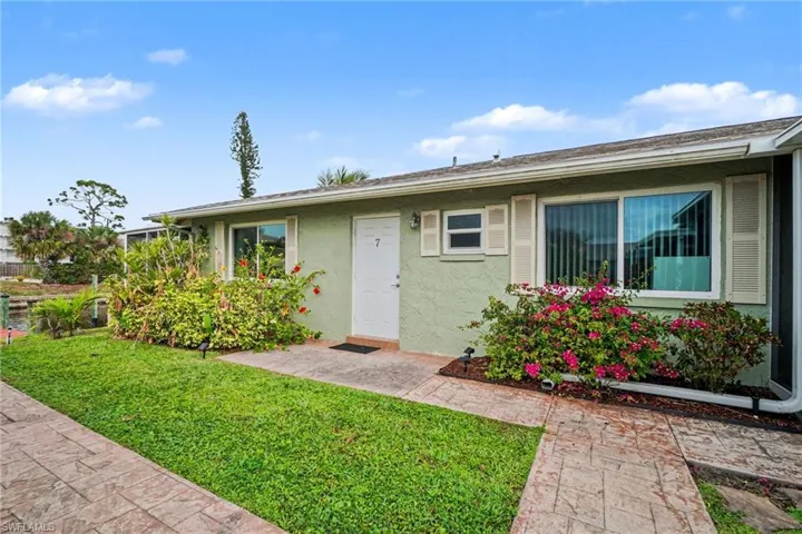 View of front of home with a front yard and stucco siding