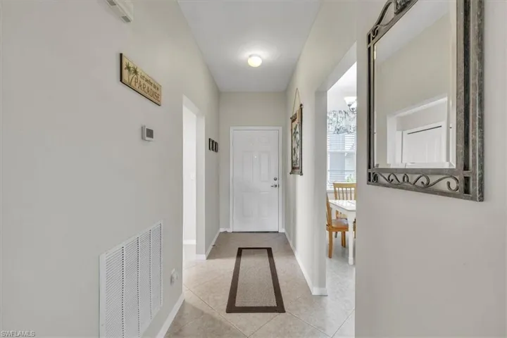 Hall featuring light tile patterned floors and baseboards