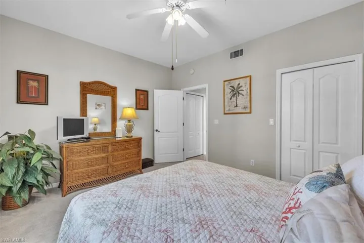 Carpeted bedroom featuring a closet and a ceiling fan