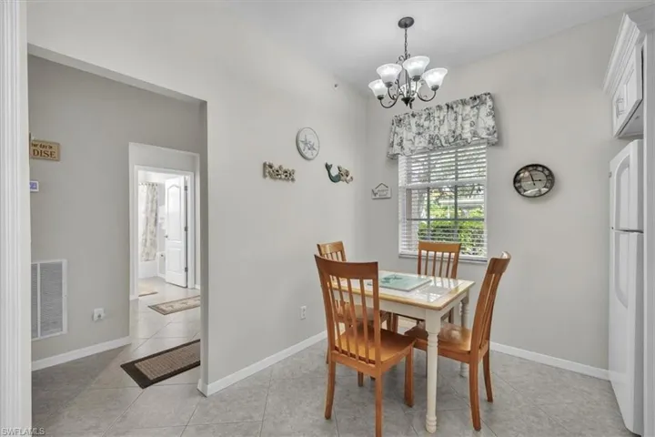 Dining room with light tile patterned flooring and a chandelier