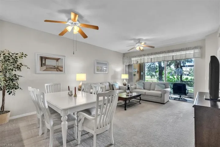 Dining room with light colored carpet and ceiling fan