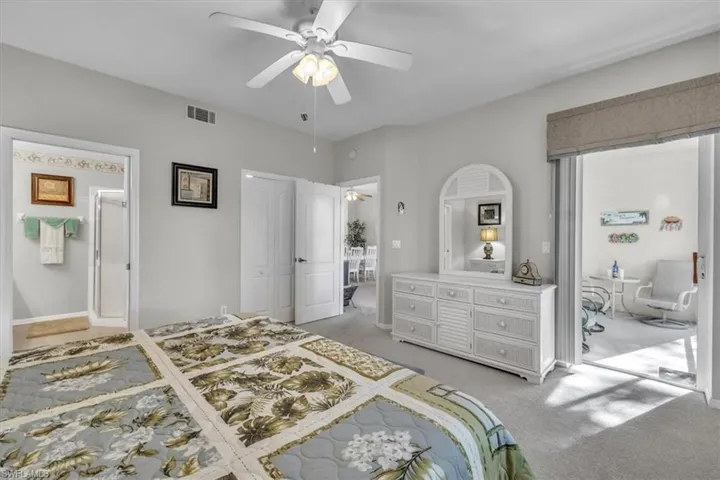Bedroom featuring light colored carpet, a ceiling fan, and a closet