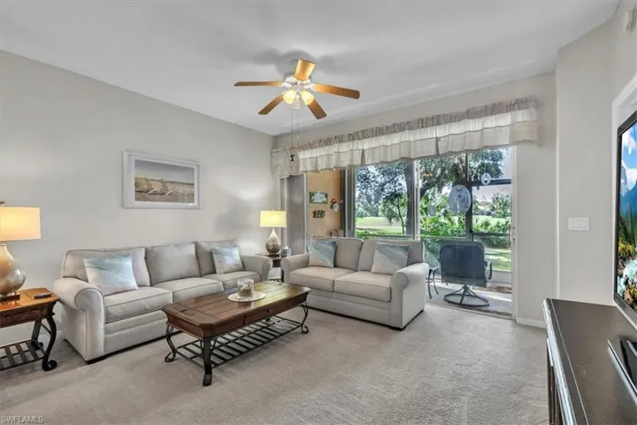 Living room featuring ceiling fan and carpet