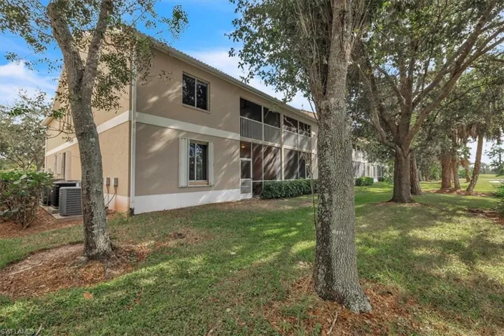Back of house featuring a sunroom, stucco siding, and a yard