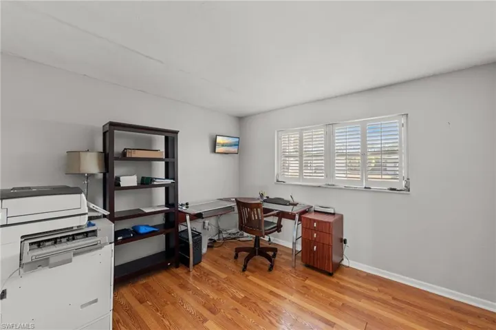 Office space with light wood-style flooring and baseboards
