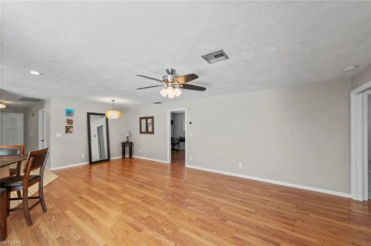 Unfurnished living room with a ceiling fan, light wood-style flooring, and a textured ceiling