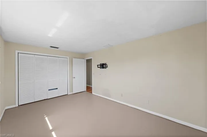 Unfurnished bedroom with concrete flooring and a closet