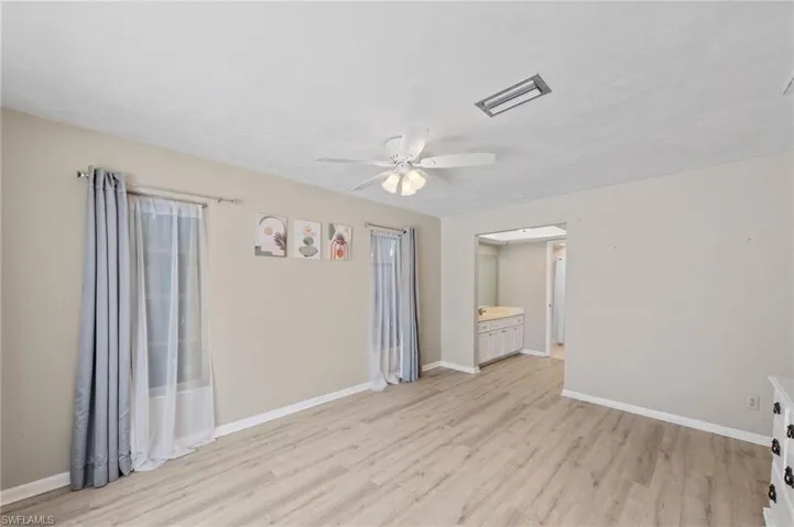 Unfurnished room with a ceiling fan and light wood-type flooring