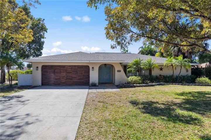 Ranch-style house featuring stucco siding, a front lawn, driveway, a garage, and a shingled roof
