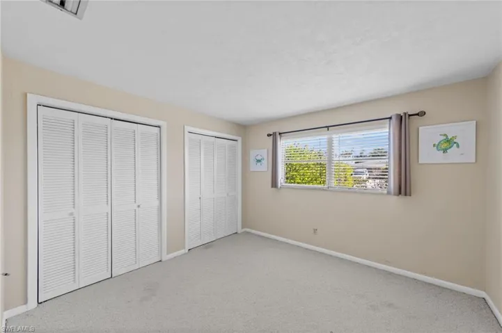 Unfurnished bedroom featuring multiple closets and carpet flooring