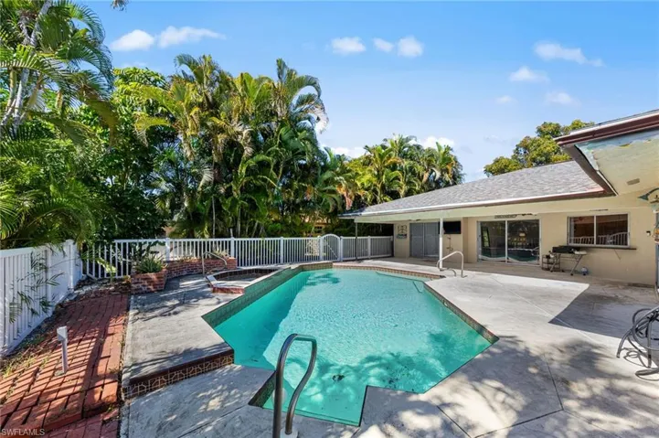 View of pool featuring patio surround, a fenced backyard, and a jacuzzi