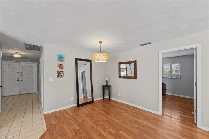 Unfurnished dining area featuring light wood-type flooring and baseboards