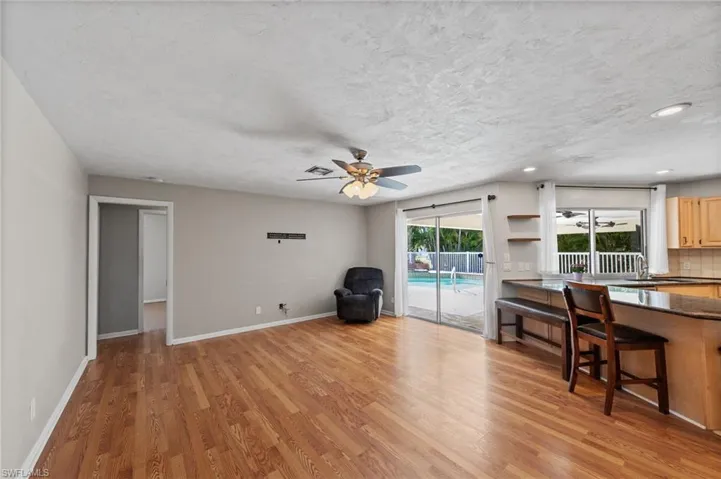 Living area with ceiling fan, light wood finished floors, a textured ceiling, and recessed lighting