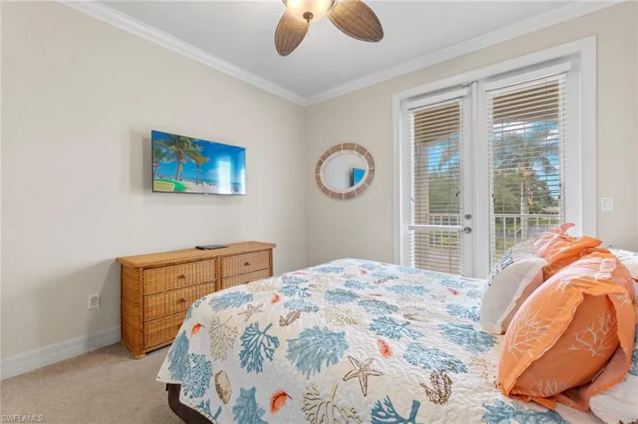 Carpeted bedroom featuring ceiling fan, crown molding, and access to outside